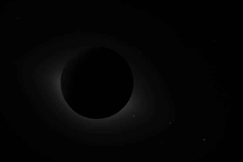 Total solar eclipse: the Moon blocks the Sun, with a faint solar corona around the edge.