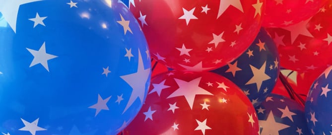Cluster of red and blue balloons with white stars, creating a festive patriotic display.